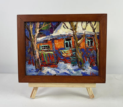 Oil painting of snowy house with orange walls by Oksana Ivanyuk
