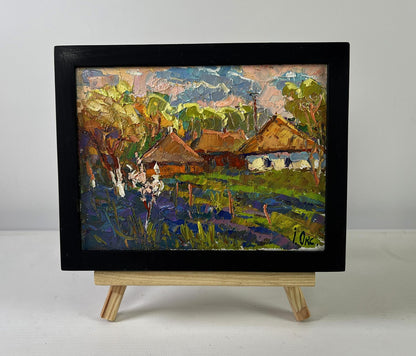 Black-framed oil painting of Oksana Ivanyuk village scene in vibrant greens