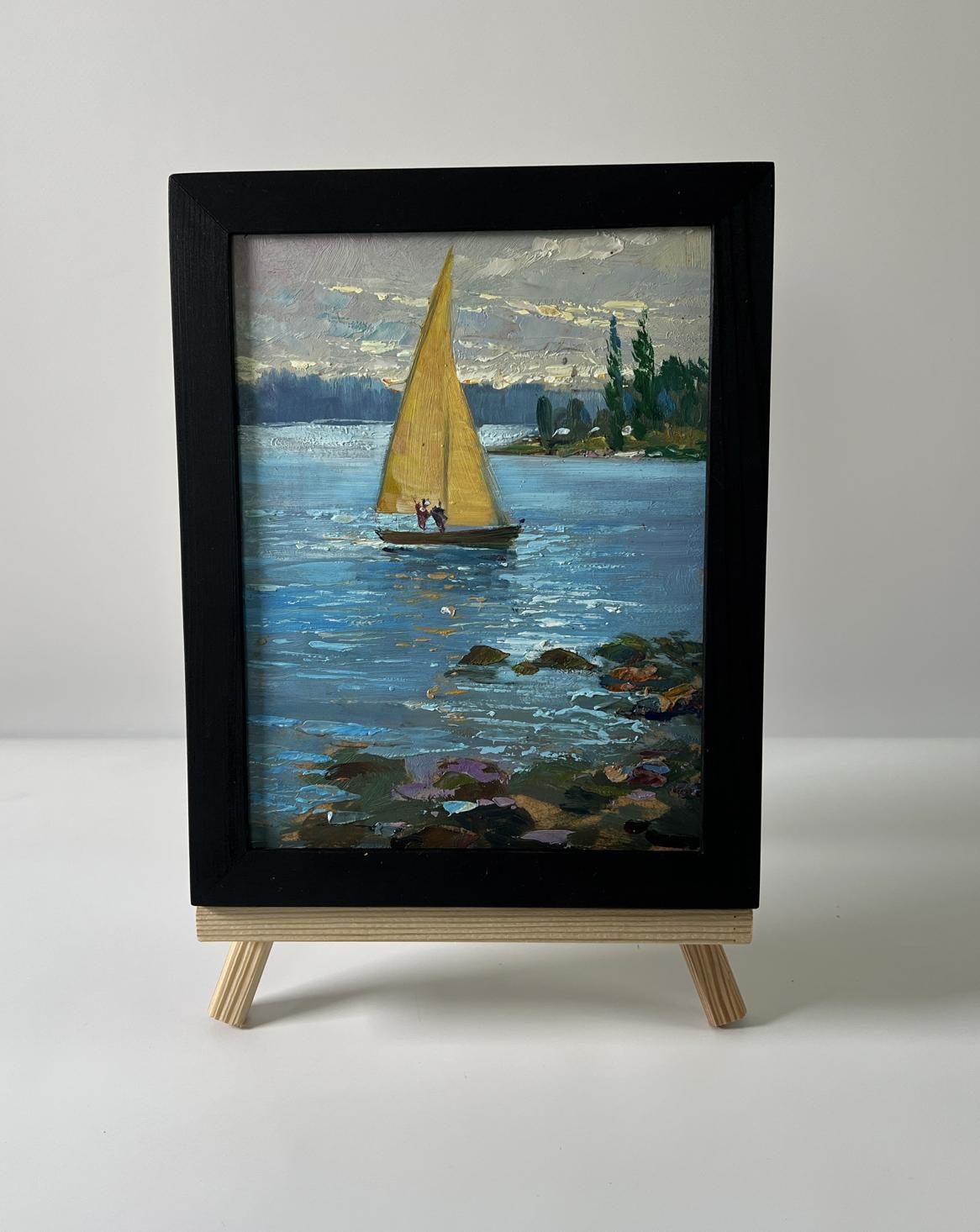 Framed oil painting of yellow-sailed boat on river by Yuriy Suprunchuk