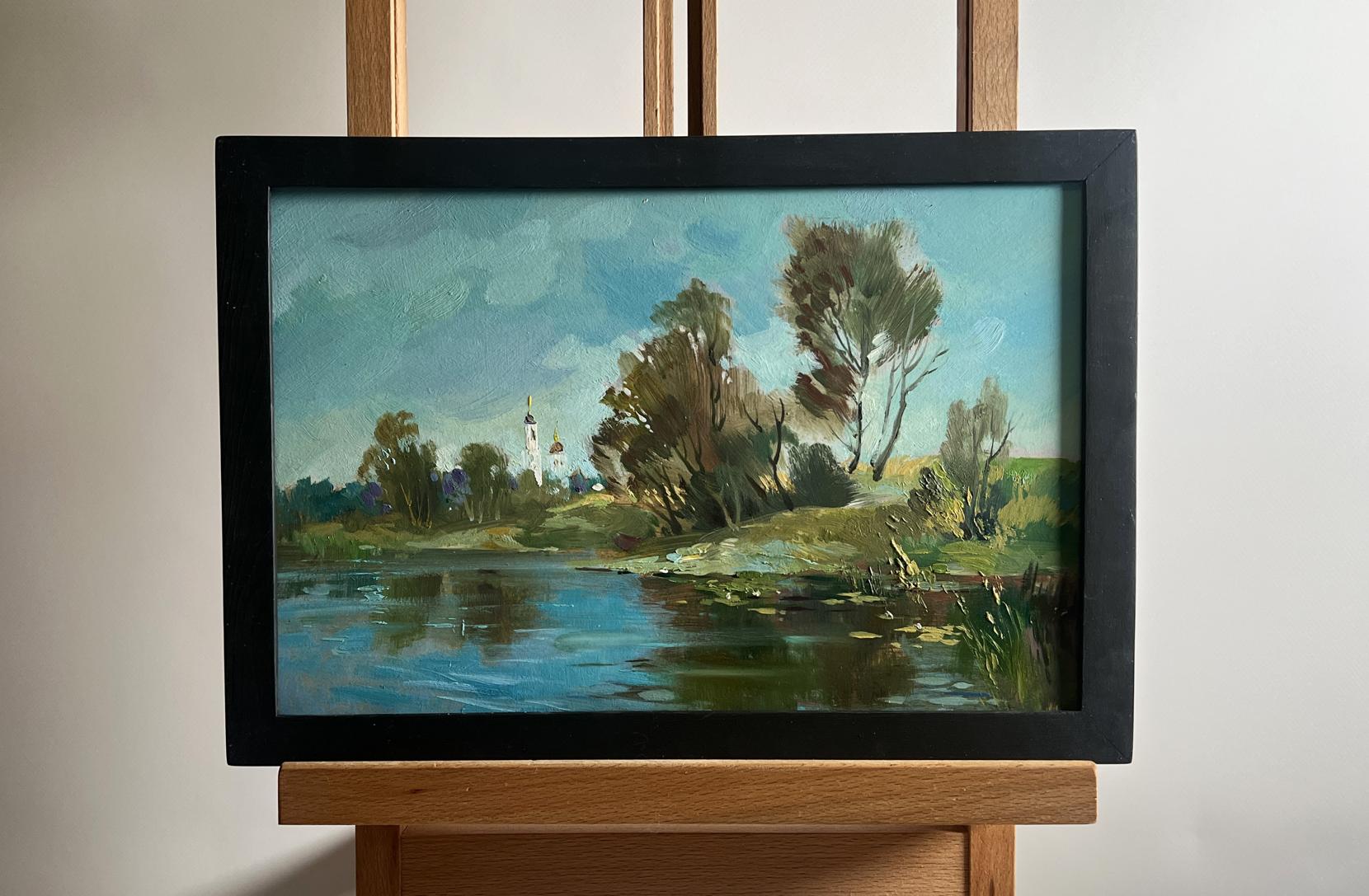 Framed oil painting of serene lakeside village landscape by Yuriy Suprunchuk