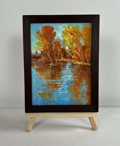 Oil painting Golden reflection of the forest by Yuriy Suprunchuk in frame on easel