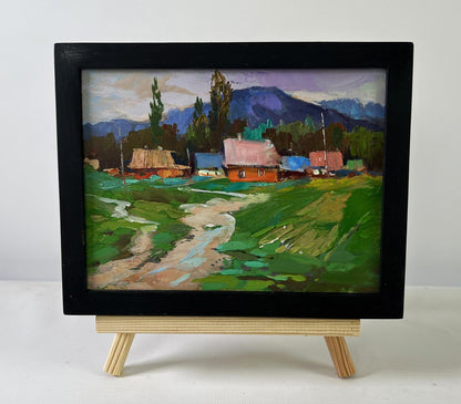 Black-framed oil painting of quiet village on hills by Yuriy Suprunchuk