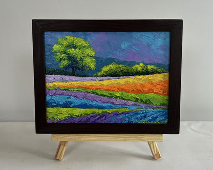 Vibrant oil painting of rainbow flower fields, green tree by V. Zadorozhnya in black frame