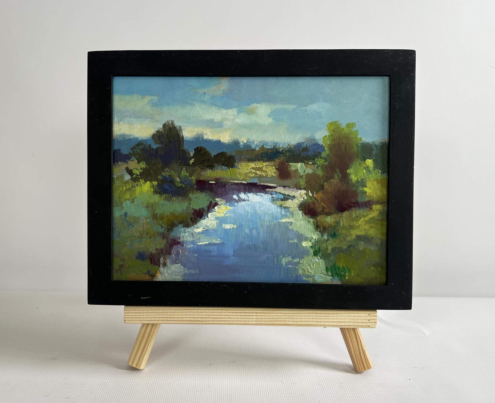 Black-framed oil painting of sunset clouds over serene river by Yuriy Suprunchuk