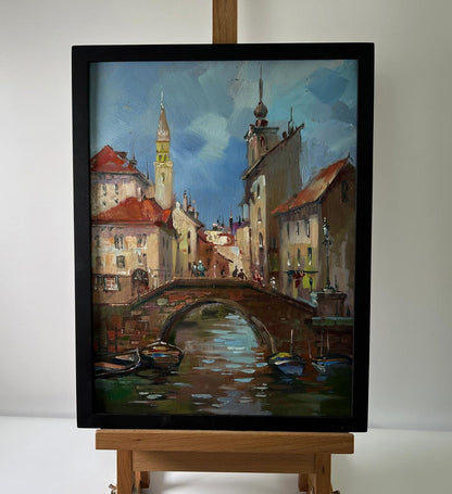 Framed oil painting of European canal city with river by Yuriy Suprunchuk