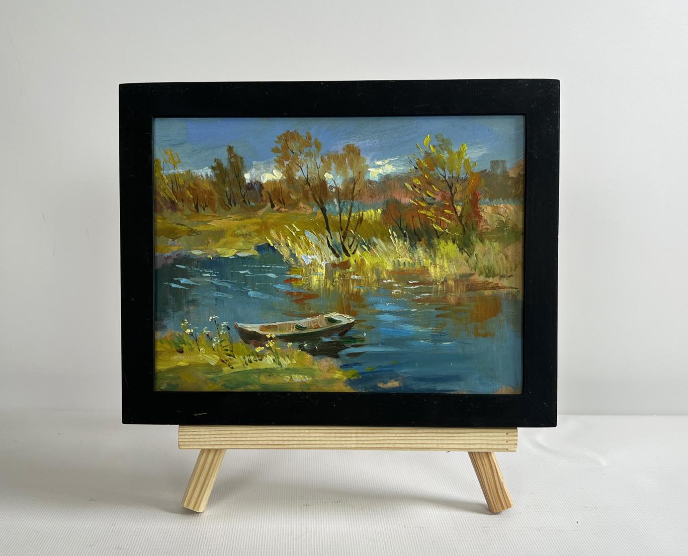 Black-framed impressionistic oil painting of autumn river with boat by Yuriy Suprunchuk
