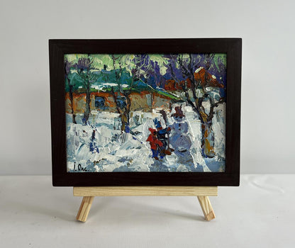 Framed oil painting by Oksana Ivanyuk of children making snowman in snow
