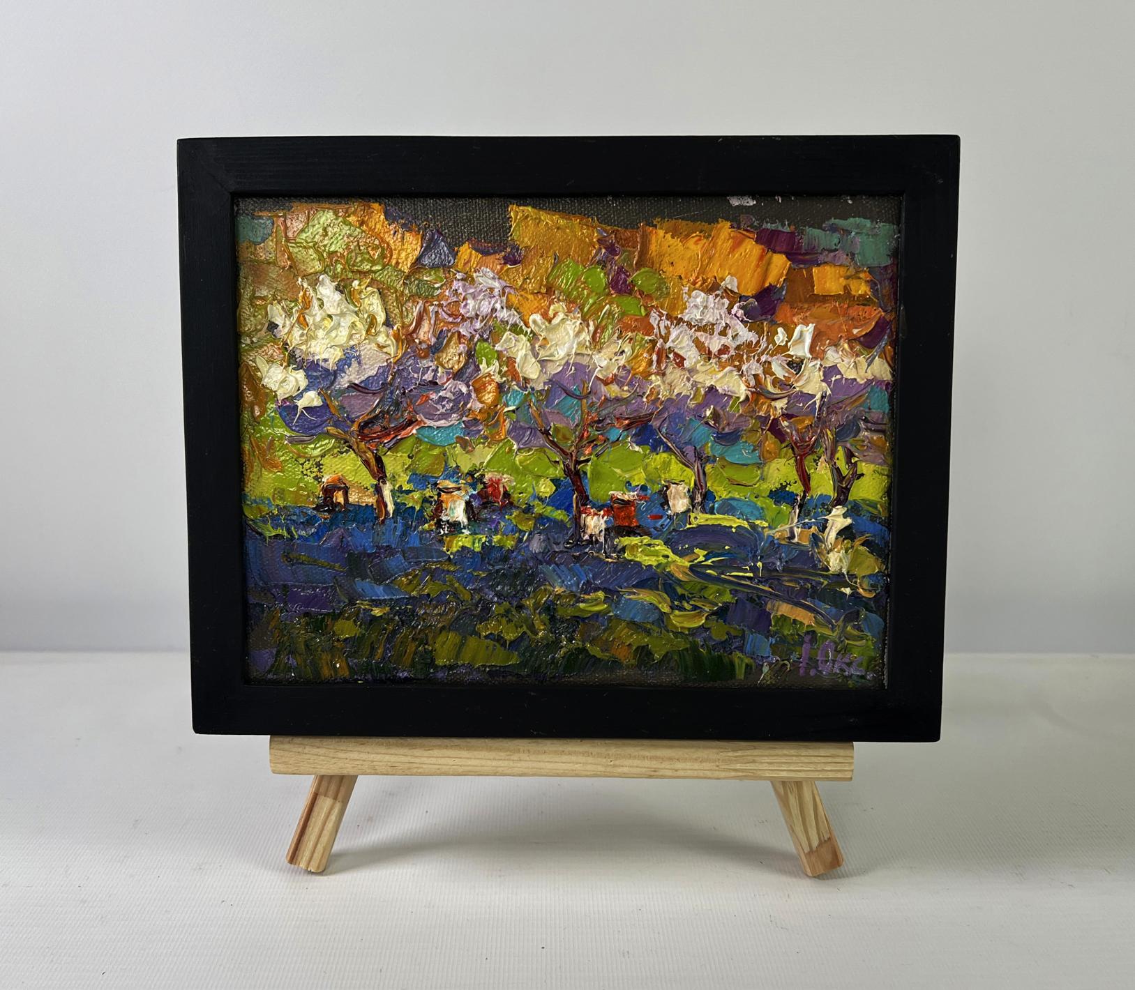 Vibrant oil painting of blossoming orchard by Oksana Ivanyuk in black frame