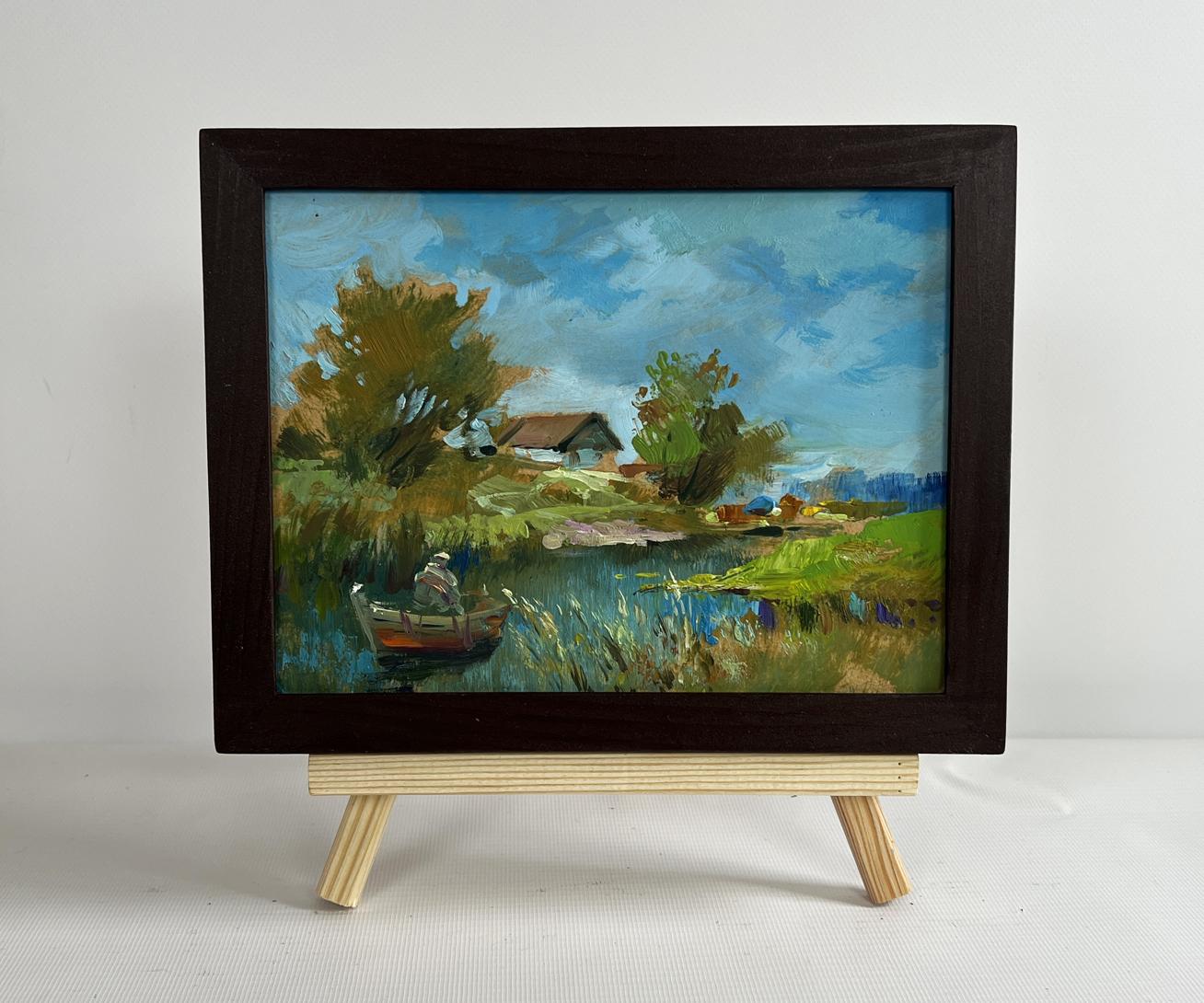 Framed oil painting of serene lakeside with boat, trees, house by Yuriy Suprunchuk