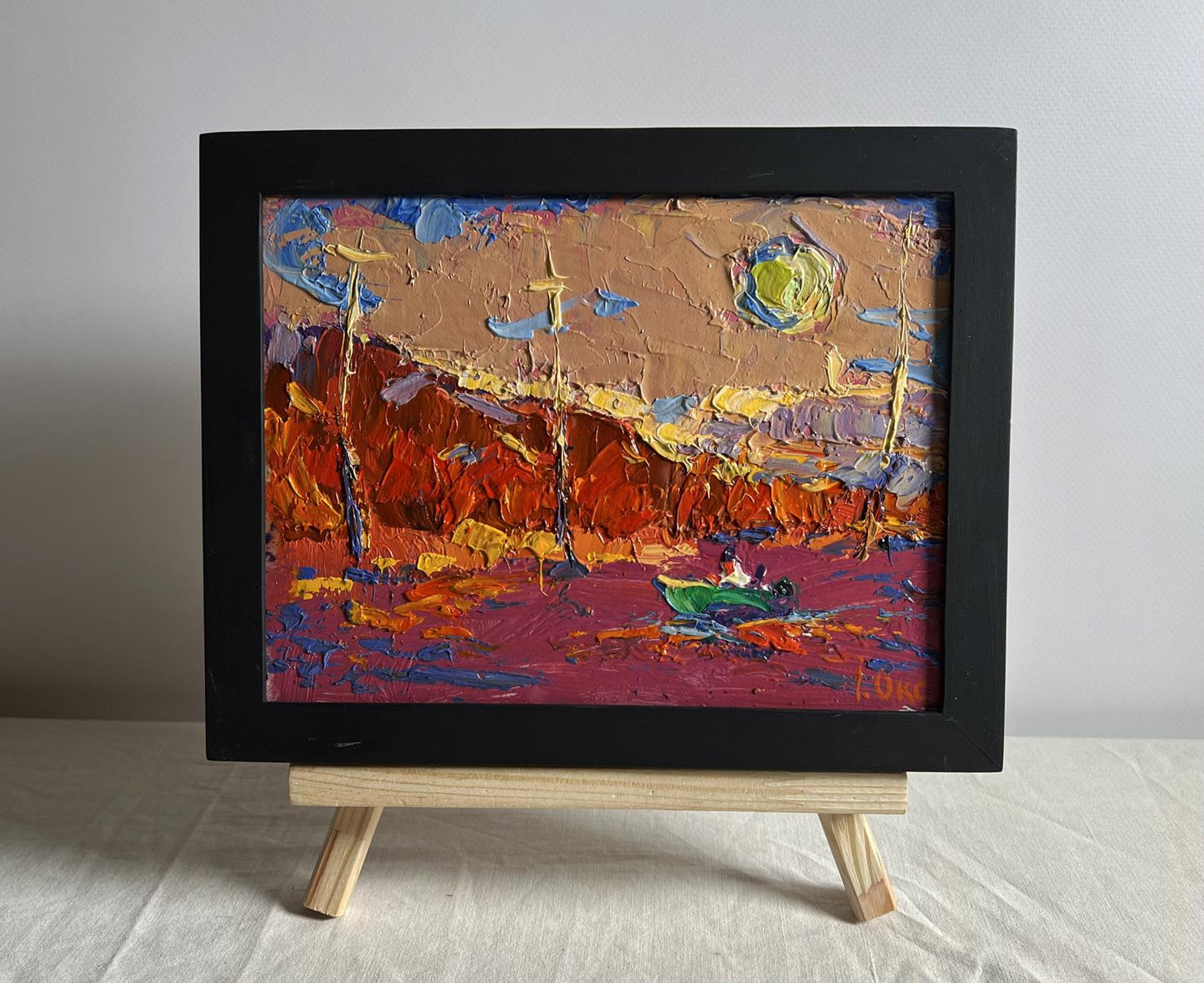 Oil painting of sailing into sunset by Oksana Ivanyuk, vibrant reds in black frame
