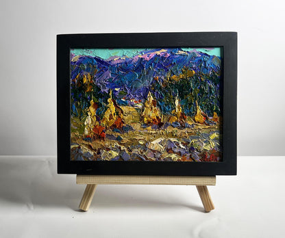 Oil painting of haystacks and mountain view with golden pagodas by Oleksiy Ivanyuk