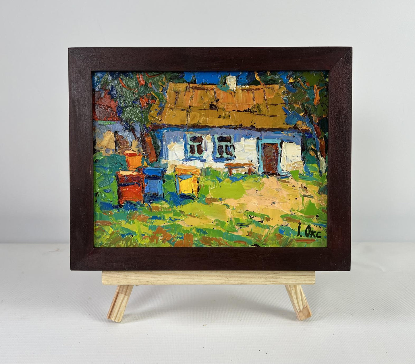 Oil painting of rustic cottage with beehives by Oksana Ivanyuk