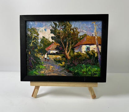 Black-framed Oil painting Street in the village by Oksana Ivanyuk, vibrant rustic scene