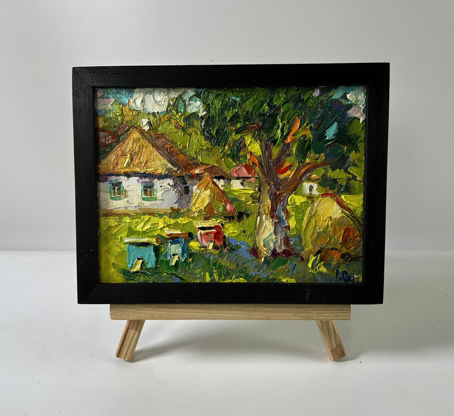 Oil painting by Oksana Ivanyuk: village yard with apiary in black frame
