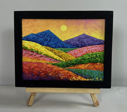 Oil painting of colorful meadow-covered mountains by V. Zadorozhnya in black frame