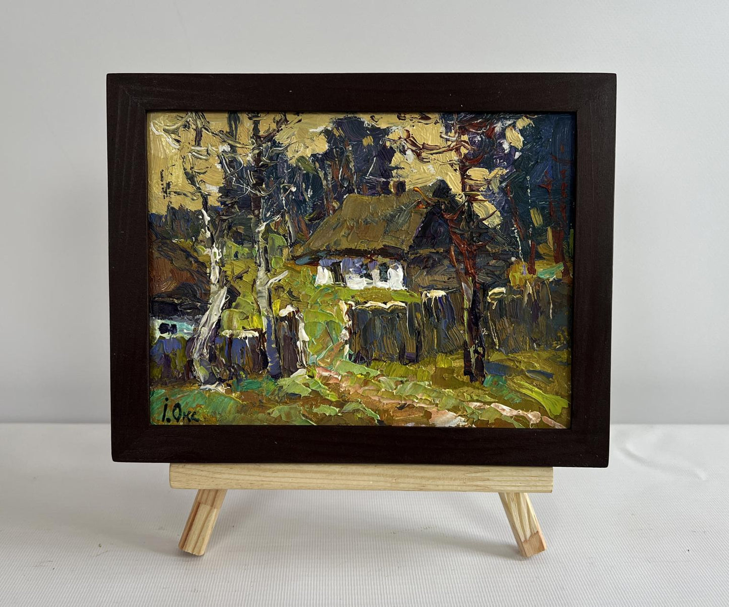 Oil painting of houses near forest by Oksana Ivanyuk in dark wood frame