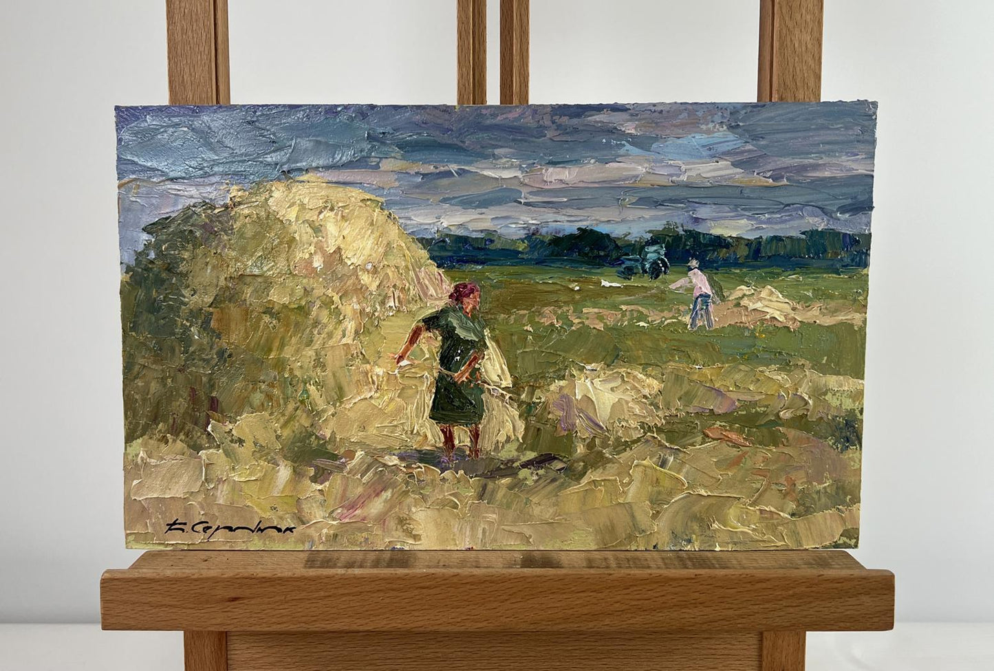 Oil painting by Boris Serdyuk: figures working in field under blue sky