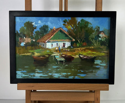 Oil painting by Yuriy Suprunchuk: rustic village with green-roofed houses, boats