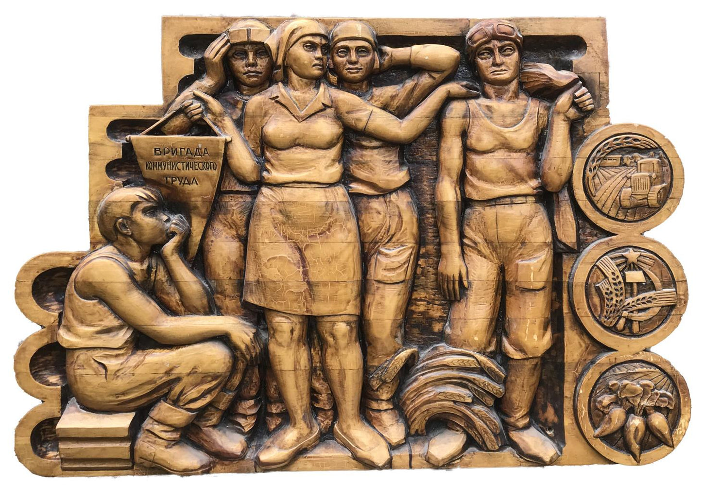 Golden-brown wooden relief of communist labor brigade workers with Cyrillic text