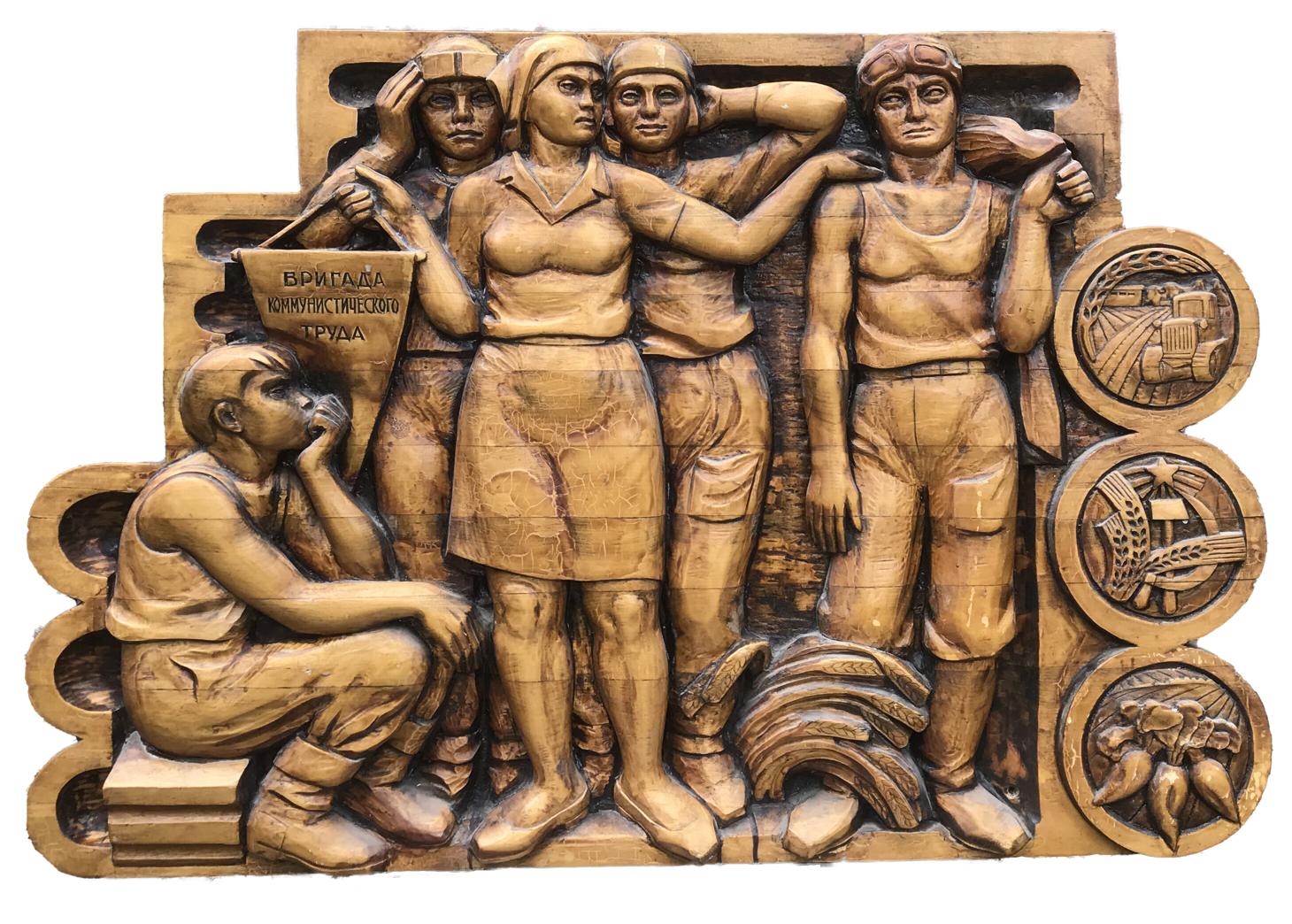 Golden-brown wooden relief of communist labor brigade workers with Cyrillic text