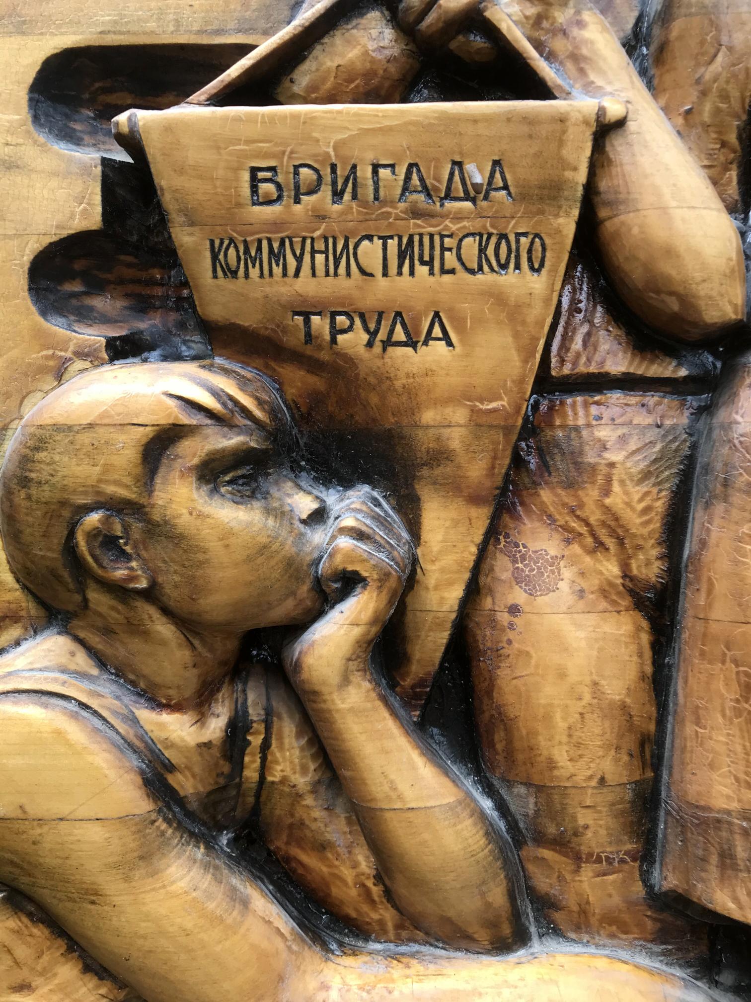 Detailed wooden relief of contemplative child under banner, Social realism Communist Labor Brigade