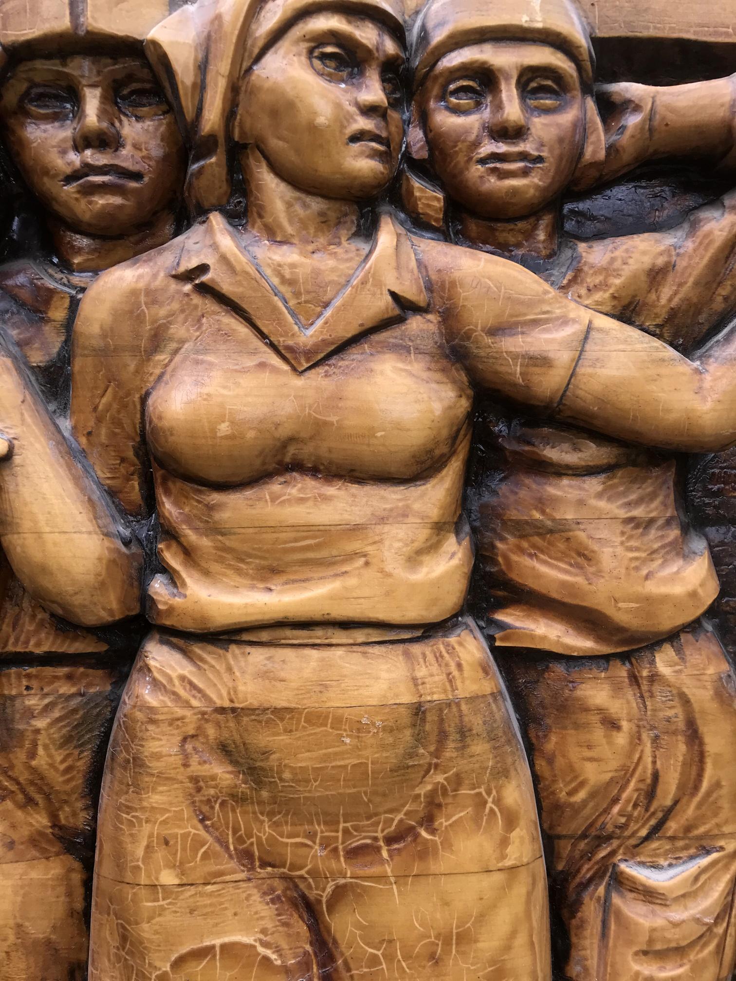 Bronze wooden relief of women in Communist Labor Brigade uniforms