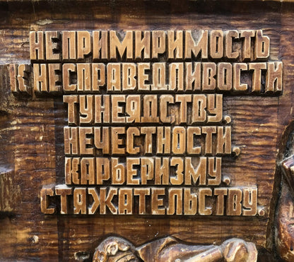 Carved wooden plaque with raised Cyrillic text on social realism theme
