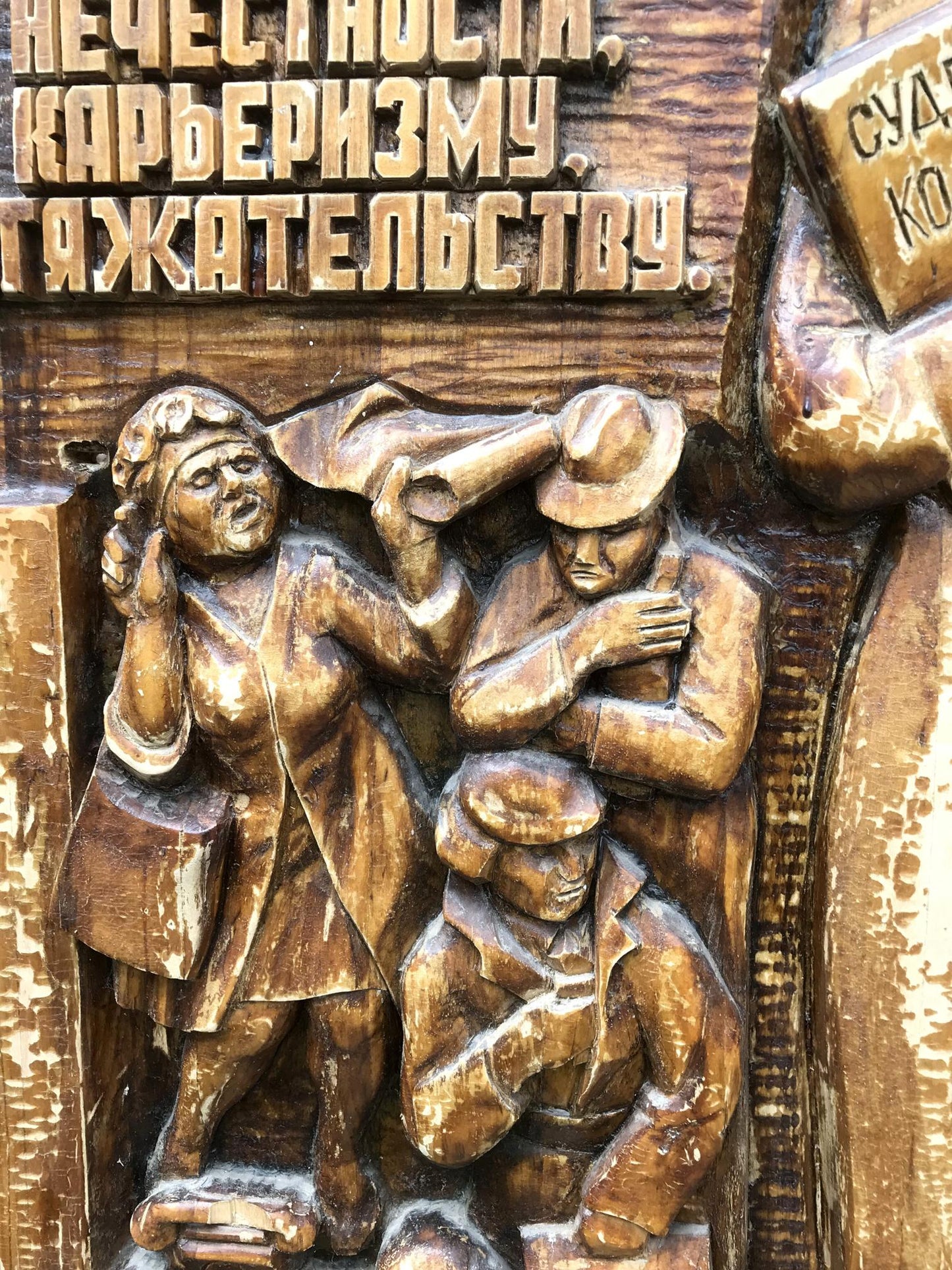 Carved wooden relief of three figures in social realism style