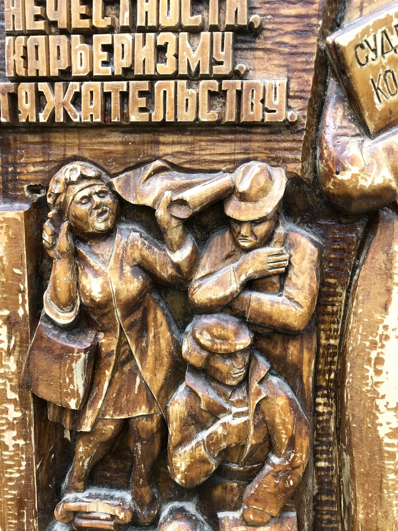 Carved wooden relief of three figures in social realism style