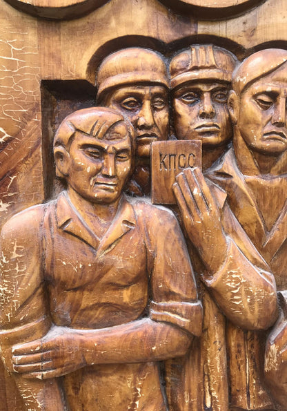 Social realism wooden relief: 4 solemn uniformed men with Cyrillic plaque