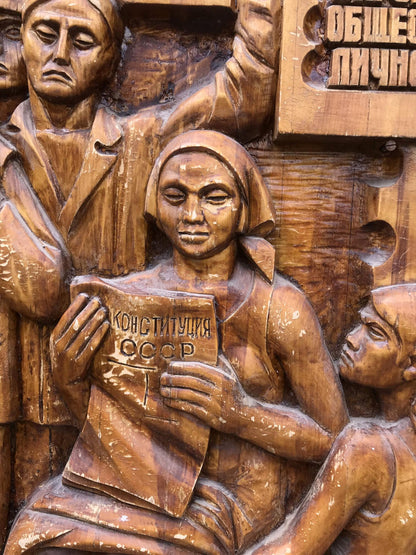 Detailed wooden relief of woman holding USSR Constitution, social realism style