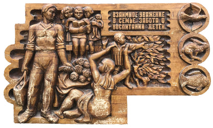 Carved wooden relief of family scene in social realism with R. text and animal motifs