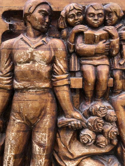 Bronze-toned wooden relief of man and children in Social realism family respect scene