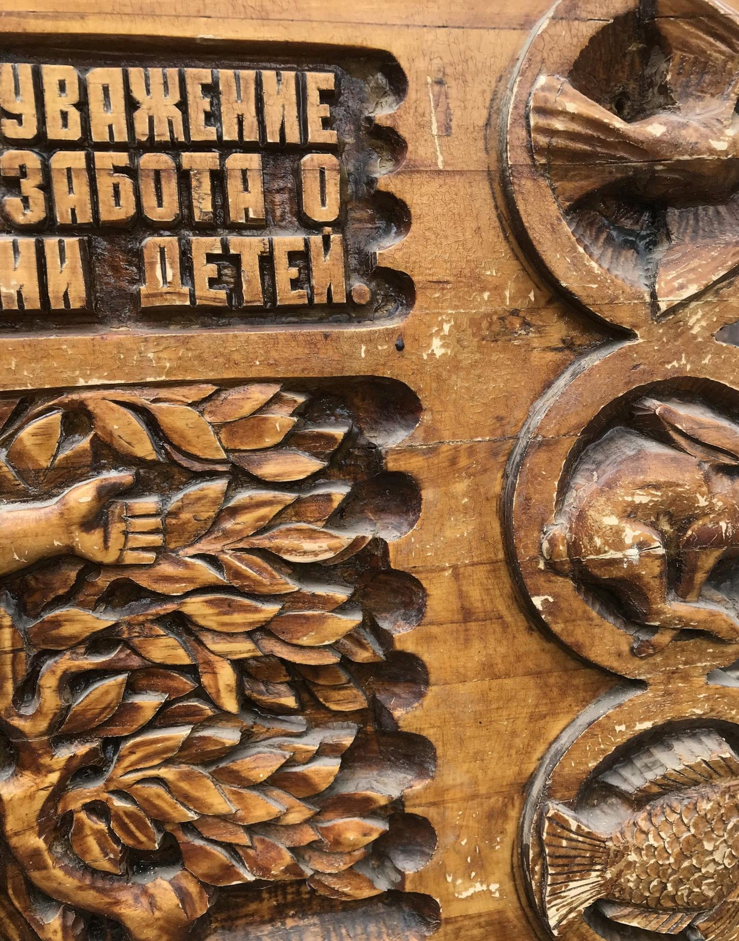 Carved wooden panel with animal foliage reliefs and Cyrillic text, Social realism family respect