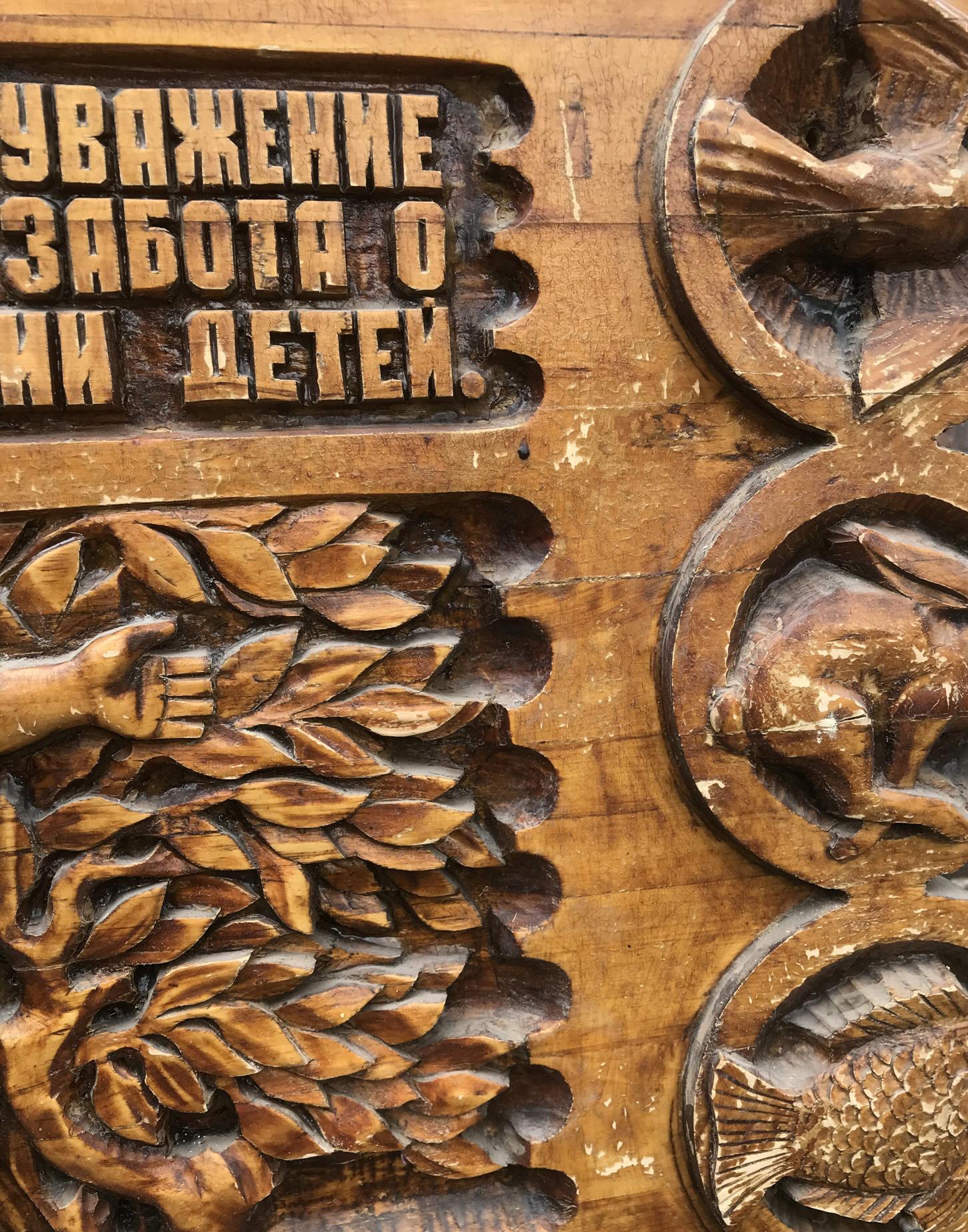 Carved wooden panel with animal foliage reliefs and Cyrillic text, Social realism family respect