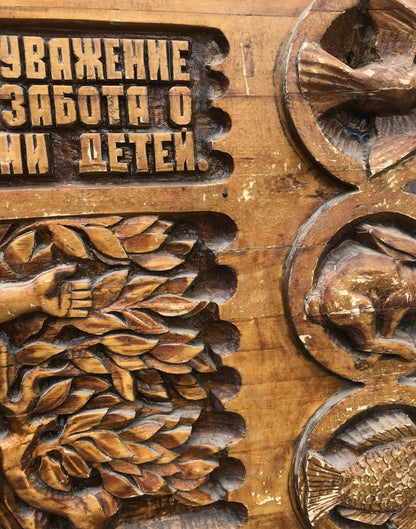 Carved wooden panel with animal foliage reliefs and Cyrillic text, Social realism family respect
