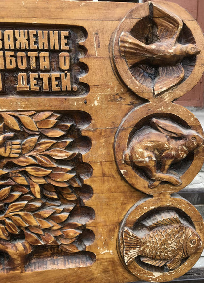 Carved wooden panel with dove, rabbit, fish in circles and wheat, social realism family respect