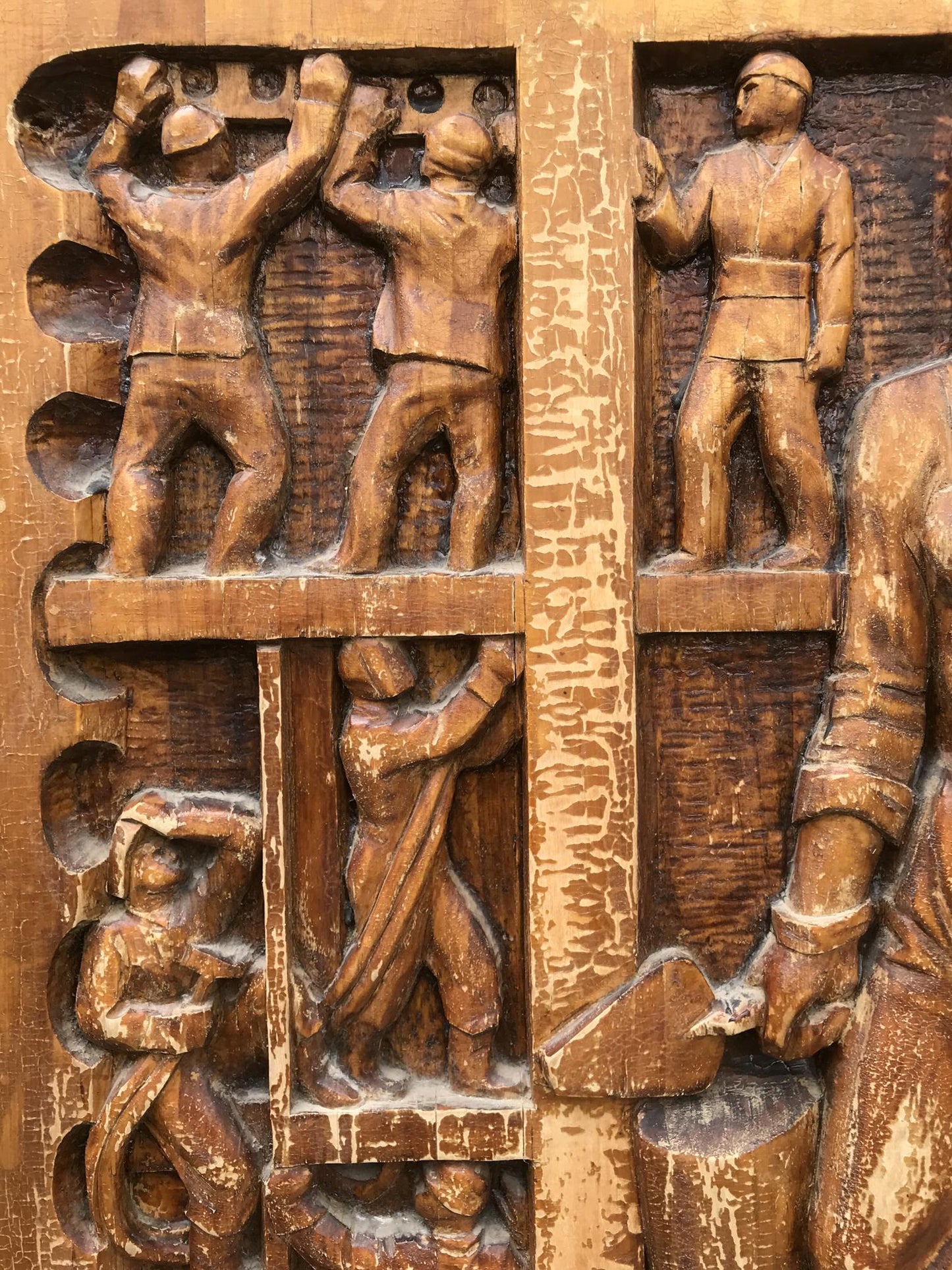 Social realism carved wooden relief of laboring workers, warm brown weathered finish
