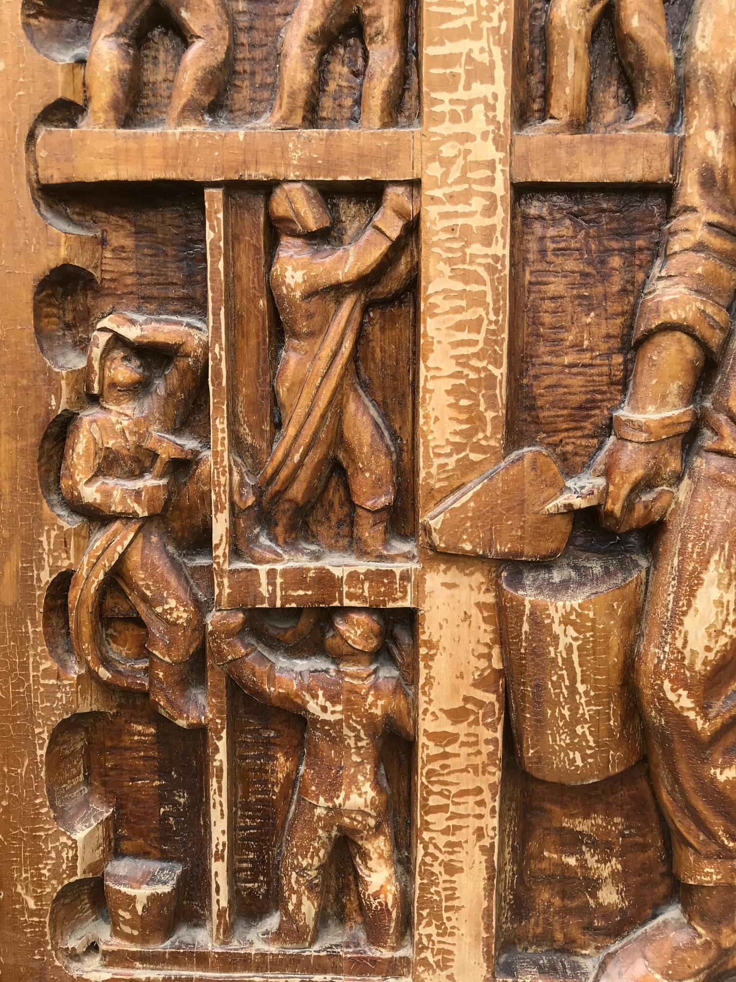 Weathered wooden relief carving of laborious figures in social realism style