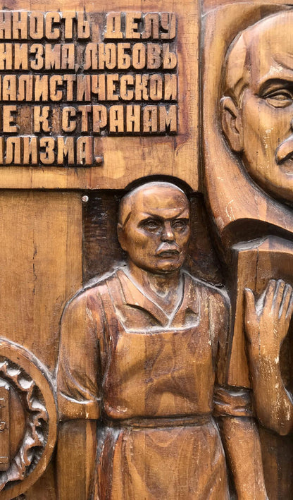 Social realism wooden relief of bald man in robe with Cyrillic text