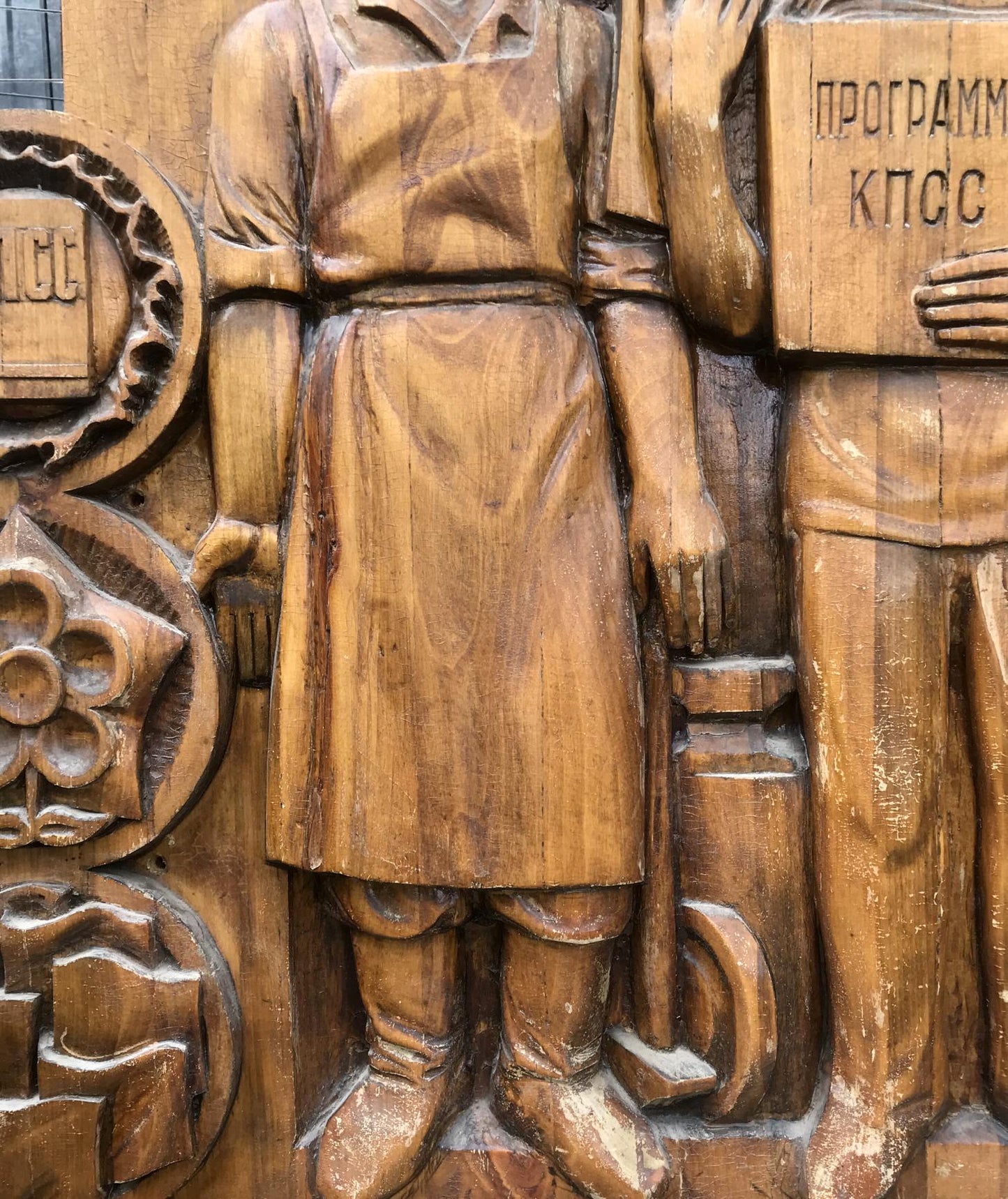 Detailed wooden carving of social realism communist devotion figure in apron and boots