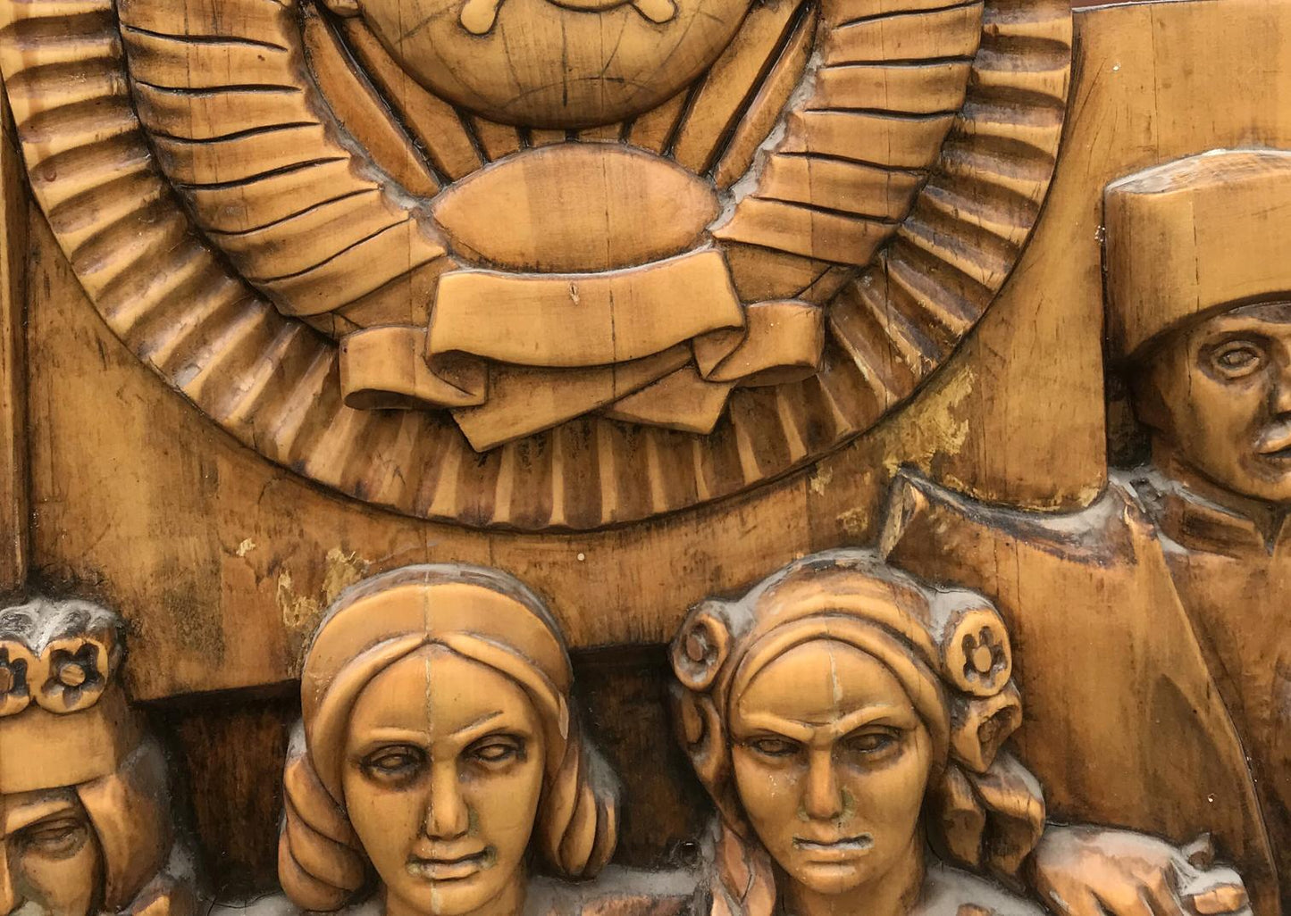 Carved wooden relief of USSR peoples friendship faces under emblem