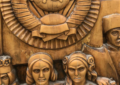 Carved wooden relief of USSR peoples friendship faces under emblem