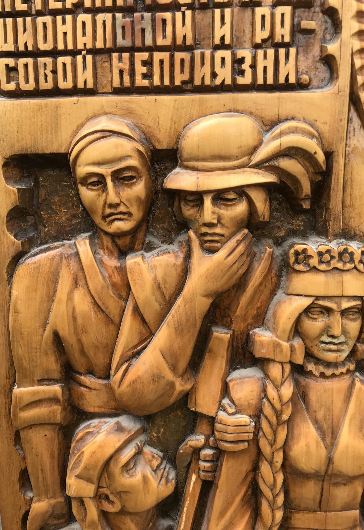 Carved wooden relief of USSR peoples friendship in traditional attire