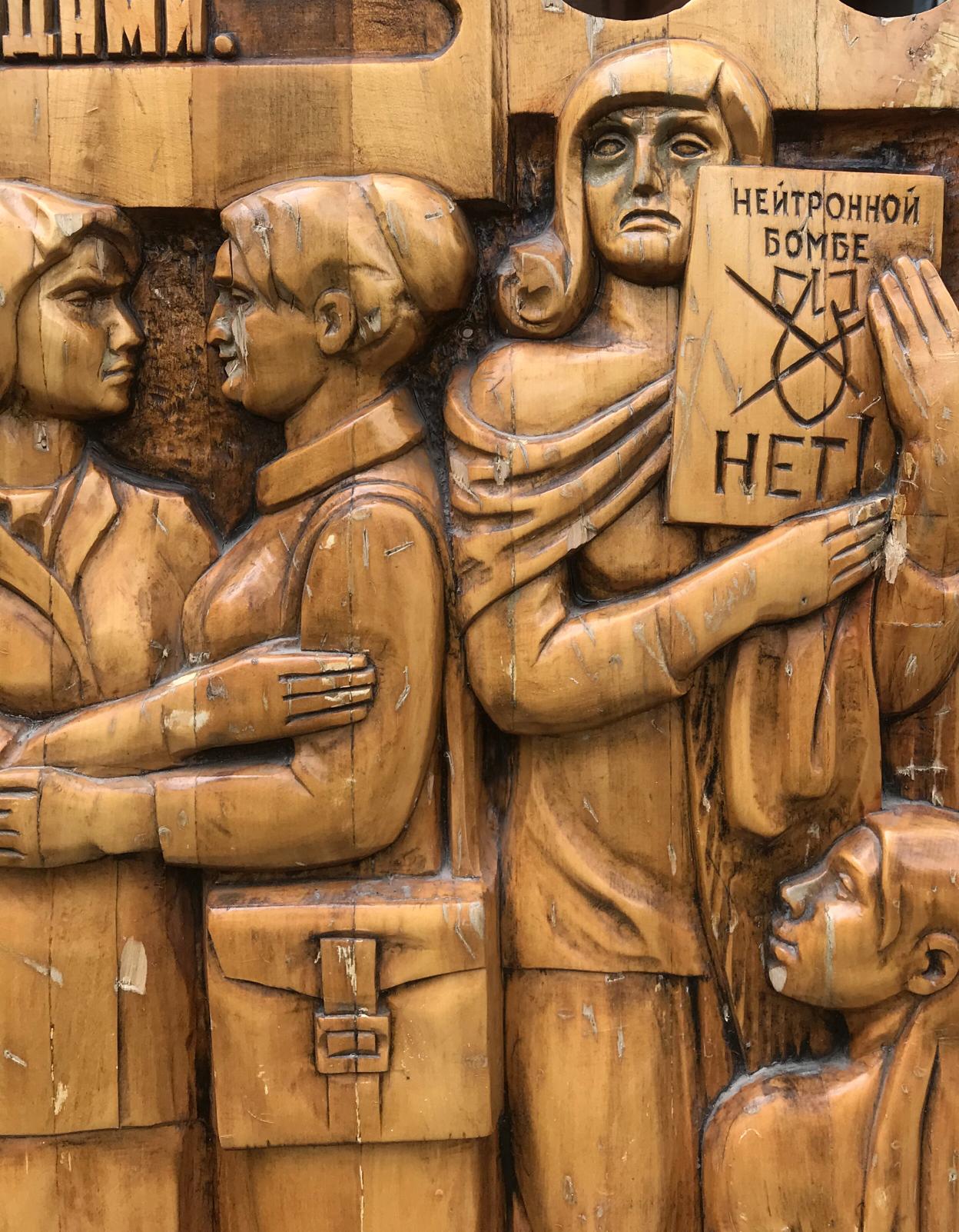 Carved wooden relief of three protesting women with Cyrillic sign, social realism fraternal solidarity