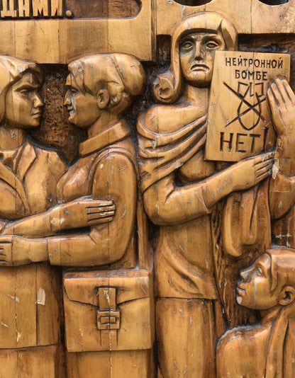 Carved wooden relief of three protesting women with Cyrillic sign, social realism fraternal solidarity