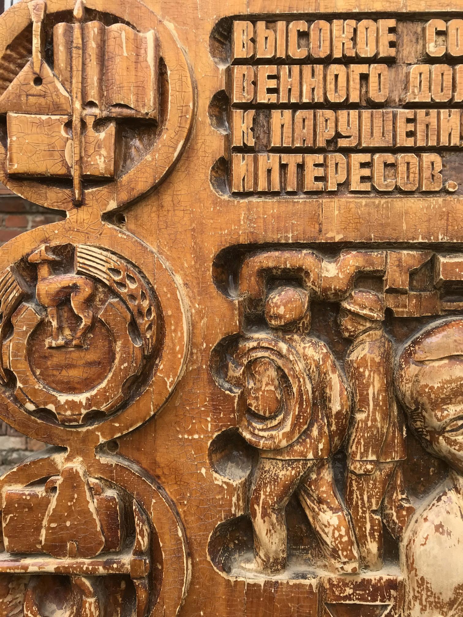 Carved wooden plaque in social realism style with cyrillic text