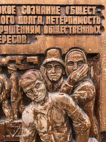 Weathered wooden relief of three expressive figures in social realism style