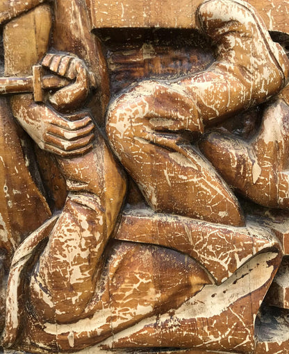 Weathered brown wooden relief of dynamic social realism figure with detailed hands and legs