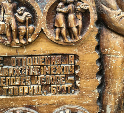 Weathered wooden plaque with social realism carvings and R. text